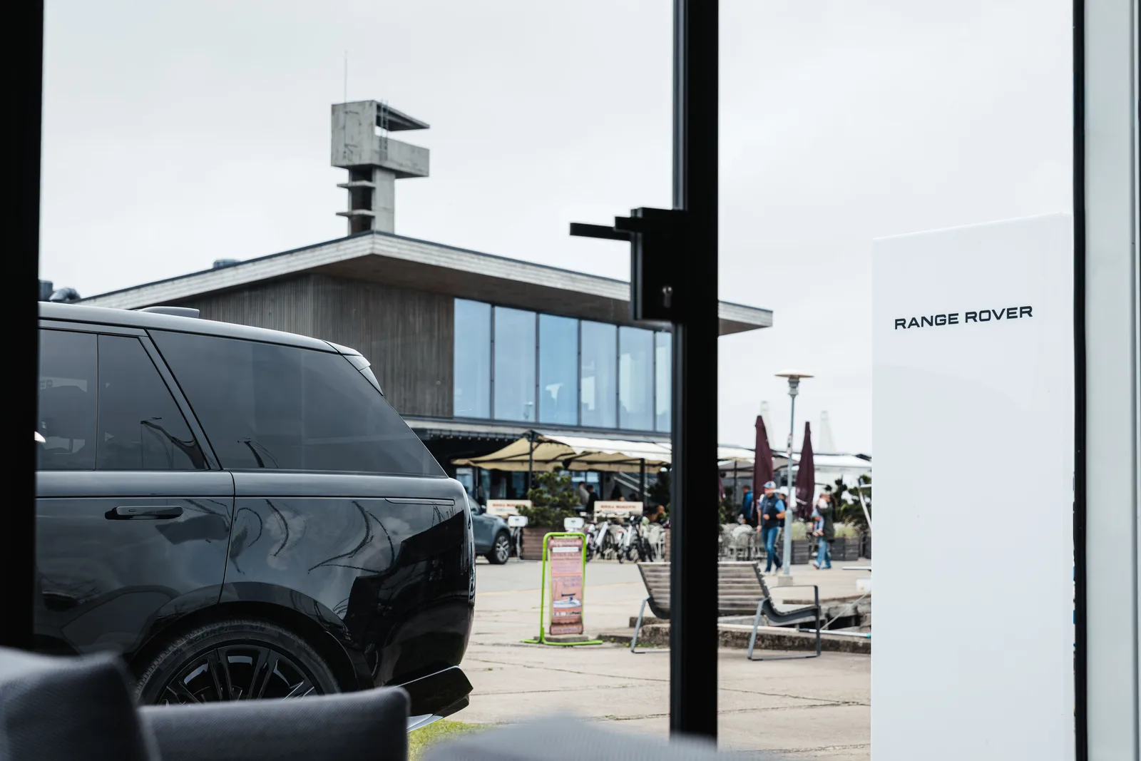 A Range Rover parked at the open glass door